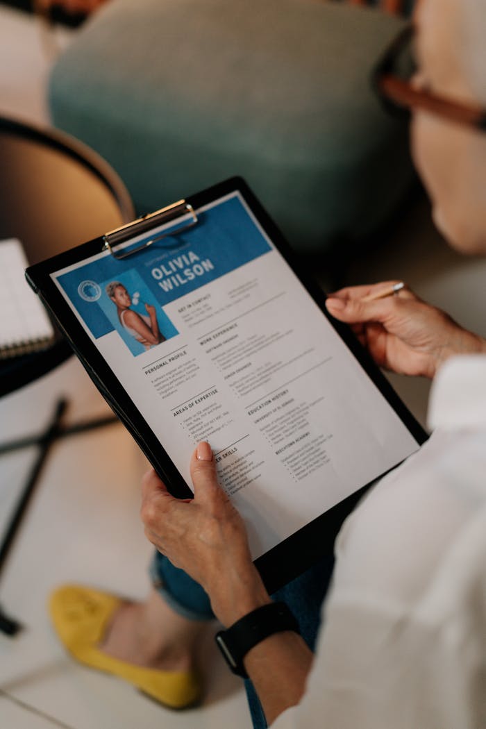 digital An HR professional reviews a resume on a clipboard during an office meeting.